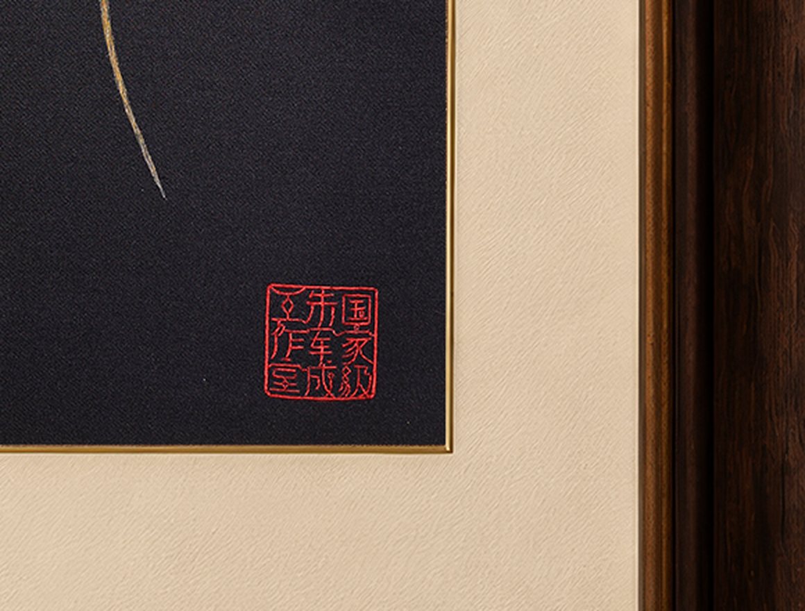 Close view of the embroidered red studio seal stitched into black silk.