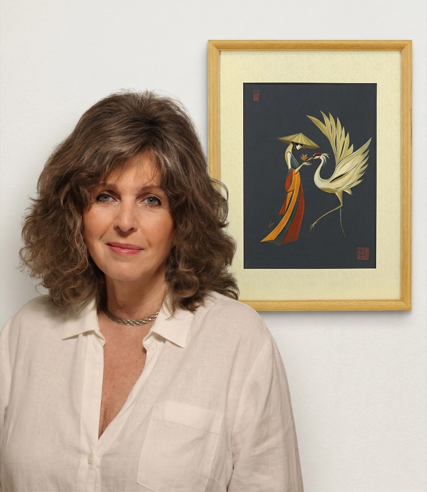 Tatyana Markovtsev standing with the framed Crane Dance artwork.